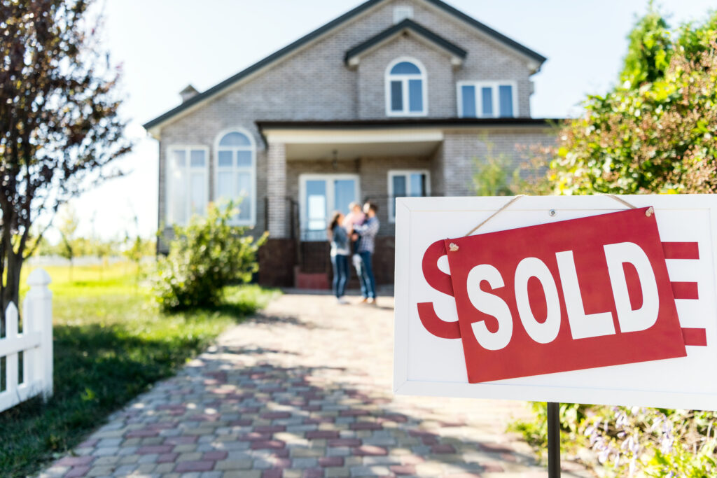 sold house with family in background, how buying or selling a house impacts the economy